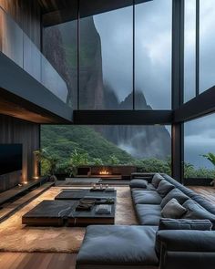 a living room with large windows and a mountain view in the backgrounge