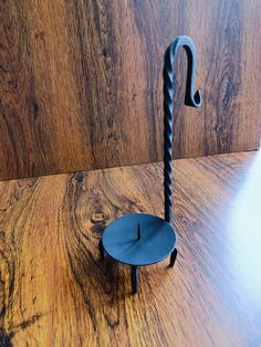 an upside down umbrella stand on a wooden floor with wood grained wall in the background