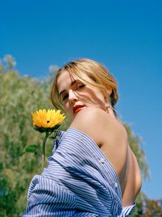 a woman with a sunflower in her hand