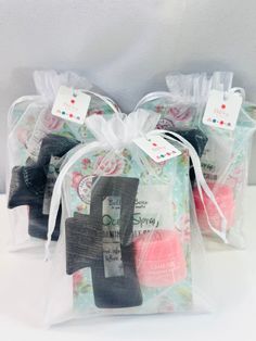 three bags filled with different types of soaps on top of a white tablecloth