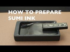 a small black object with the words how to prepare sumi ink