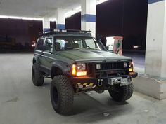 a jeep parked in a parking garage with its lights on and the front bumper up