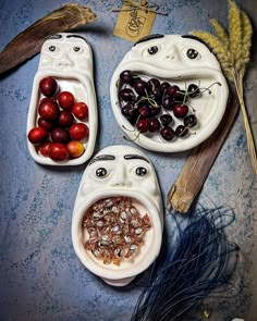 three bowls filled with cherries and seeds on top of a table