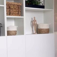 a white bookcase with baskets on top of it