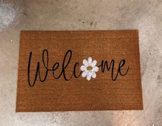 a welcome mat with a white flower on it