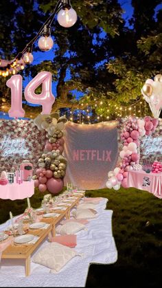 a table topped with balloons and cake next to a sign that says'14 '