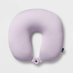 a pink neck pillow with an eye patch on the front and side, sitting against a white background