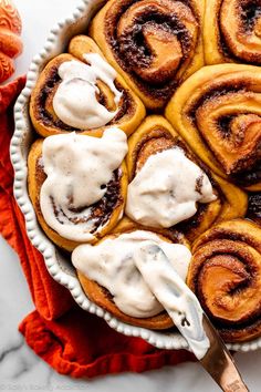 cinnamon rolls with icing in a white dish