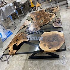 the table is made out of wood and has black metal legs with an interesting design