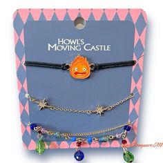 Studio Ghibli's Howl's Moving Castle Bracelet Set Featuring Calcifer And Multi-Colored Gems And Sparkle Shapes. One Size Fits Most, Adjustable, Made Of Alloy, Cord, And Acrylic. Set Of 3. New. Howls Moving Castle Gift Ideas, Howls Moving Castle Birthday Party, Howls Moving Castle Jewelry, Howls Moving Castle Door Dial, Howls Moving Castle Matching Rings, Howl's Moving Castle Clothes, Howls Moving Castle Inspired Jewelry, Howls Moving Castle Accessory, Howls Moving Castle Merchandise