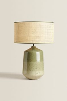 a green ceramic table lamp with a beige shade