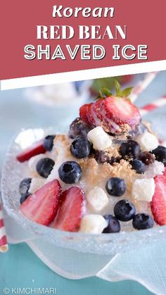 a bowl filled with strawberries, blueberries, and other fruit on top of a table