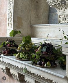 several baskets filled with fruit sitting on top of a mantle