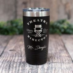 a black and silver tumbler with the words theatre director on it sitting on a wooden table