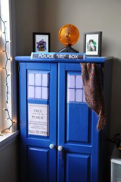 a blue police box cabinet with pictures on top