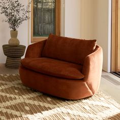 a living room with a chair and vase on the floor