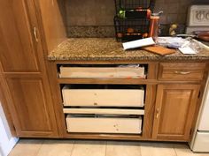 a kitchen with wooden cabinets and marble counter tops that have been stripped off from the floor