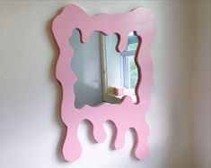 a pink mirror mounted to the side of a wall