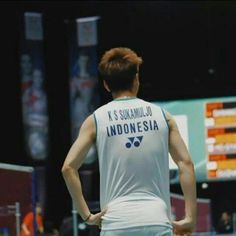 a man standing on top of a tennis court with his back turned to the camera