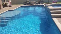 an empty swimming pool with steps leading up to the side and chairs on the other side