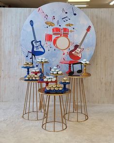 cupcakes and cakes are arranged in front of a wall with musical instruments on it