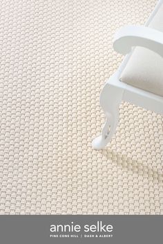 a white chair sitting on top of a carpet covered floor