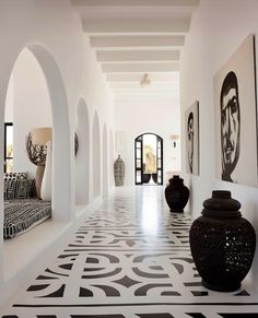 the hallway is decorated with black and white art on the walls as well as large vases