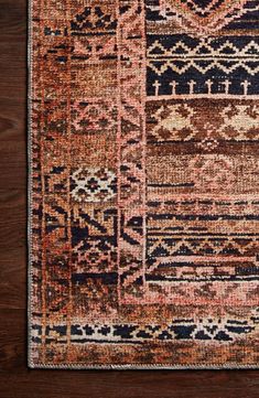 an area rug with various colors and patterns on it, including brown, blue, pink, orange and black