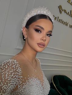 a woman wearing a tiara and pearls on her head