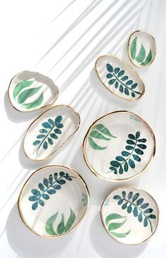 four plates with leaves painted on them