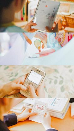 two people sitting at a table with cell phones and books in front of their faces