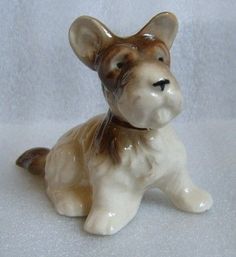 a ceramic figurine of a dog on a white background