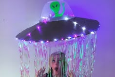 a woman is standing in front of an alien tent with lights on it's head