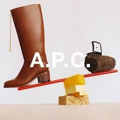 a pair of brown boots sitting on top of a seesaw next to a piece of bread