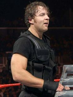 a man standing next to a ladder in front of a crowd at a wrestling match