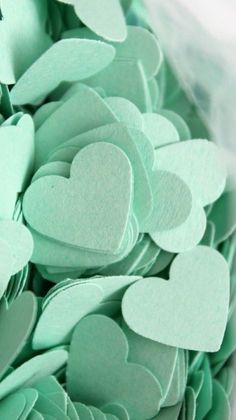 green paper hearts are arranged in the shape of heart's on top of each other