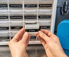 two hands are holding up some sort of small plastic box with labels on it that say cup hooks