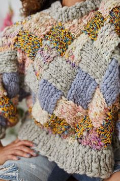 a close up of a woman wearing a knitted sweater