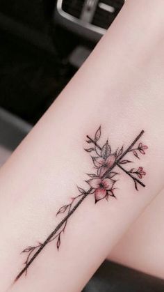 a woman's leg with a flower tattoo on the side of her arm,