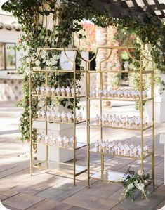 an outdoor wedding ceremony setup with white flowers and greenery hanging from the pergolated roof