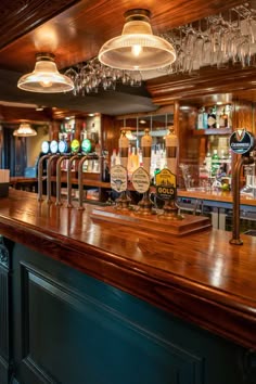 Glossy wooden bar with glasses hung above and with a variety of beers on draught. Bar And Pub Design, Australian Pub Interior, Pub Interior Ideas Modern, Irish Bar Design, Pub Lighting Ideas, Pub Astethic, Traditional Pub Interior, Pub Bar Ideas