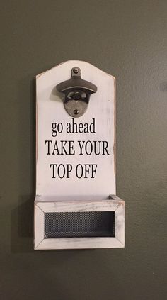 a sign on the wall that says go ahead take your top off with an iron grate