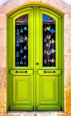 an open green door with ornaments hanging on it