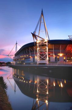 the sun is setting at an outdoor stadium with water reflecting off it's surface