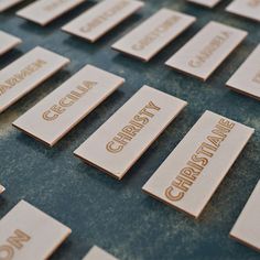 wooden name tags are arranged in rows on a blue surface with white writing that reads carolina