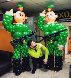 a man standing next to two giant balloons in the shape of cartoon characters