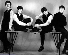 four young men sitting on top of a table