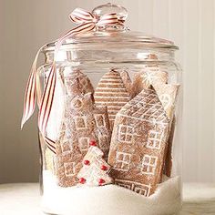 a glass jar filled with gingerbread cookies on top of a table