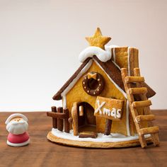 a gingerbread house with a santa clause figure next to it