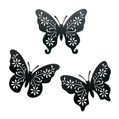 three black butterflies with white flowers on the wings and one is cut out from paper